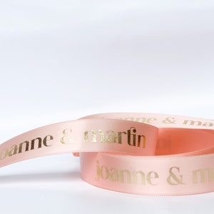 Light pink satin ribbon with gold printed letters "joanne & martin"