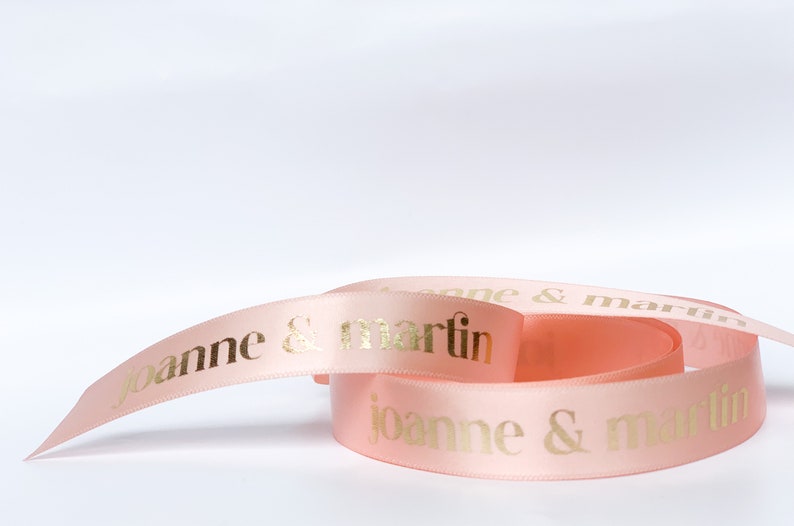 Light pink satin ribbon with gold printed letters "joanne & martin"