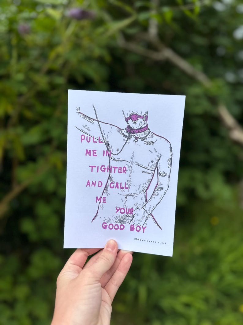 May include: A black and white illustration of a person with a pink gag in their mouth and a pink collar around their neck. The person is wearing a pink choker and has a pink ring on their finger. The text "PULL ME IN TIGHTER AND CALL ME YOUR GOOD BOY" is written in pink letters on the white background.