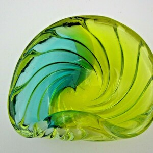 Puede incluir: Un cuenco de vidrio con forma de espiral con un dise&ntilde;o azul y verde. El cuenco est&aacute; hecho de vidrio transparente y tiene una forma &uacute;nica y org&aacute;nica.