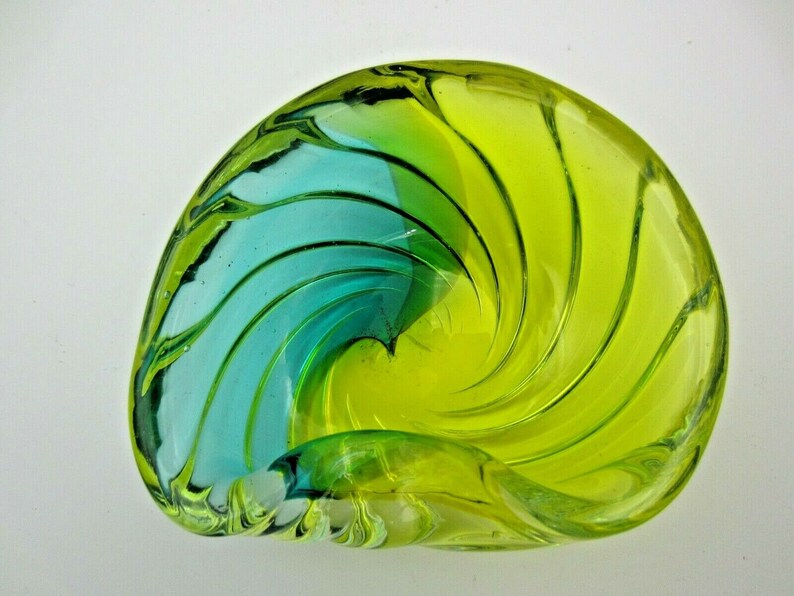 Puede incluir: Un cuenco de vidrio con forma de espiral con un dise&ntilde;o azul y verde. El cuenco est&aacute; hecho de vidrio transparente y tiene una forma &uacute;nica y org&aacute;nica.