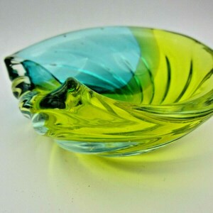 Puede incluir: Un cuenco de vidrio en forma de espiral con un degradado de color azul y verde. El cuenco est&aacute; hecho de vidrio transparente y tiene una forma redonda y lisa.