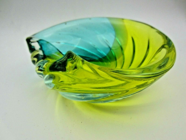 Puede incluir: Un cuenco de vidrio en forma de espiral con un degradado de color azul y verde. El cuenco est&aacute; hecho de vidrio transparente y tiene una forma redonda y lisa.
