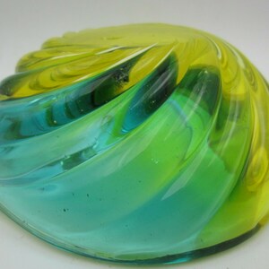 Puede incluir: Un cuenco de vidrio en espiral con un esquema de color azul y amarillo. El cuenco est&aacute; hecho de vidrio transparente con un patr&oacute;n de espiral azul y amarillo.