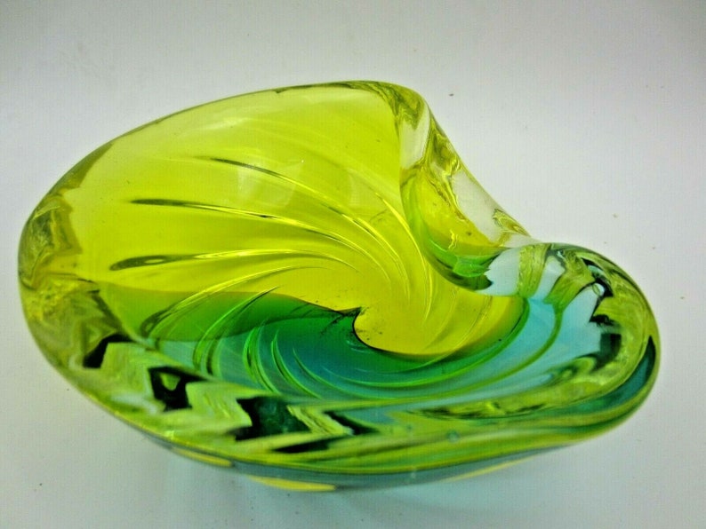 Puede incluir: Un cuenco de vidrio verde y azul con un dise&ntilde;o de espiral. El cuenco est&aacute; hecho de vidrio transparente con un patr&oacute;n de espiral verde y azul.