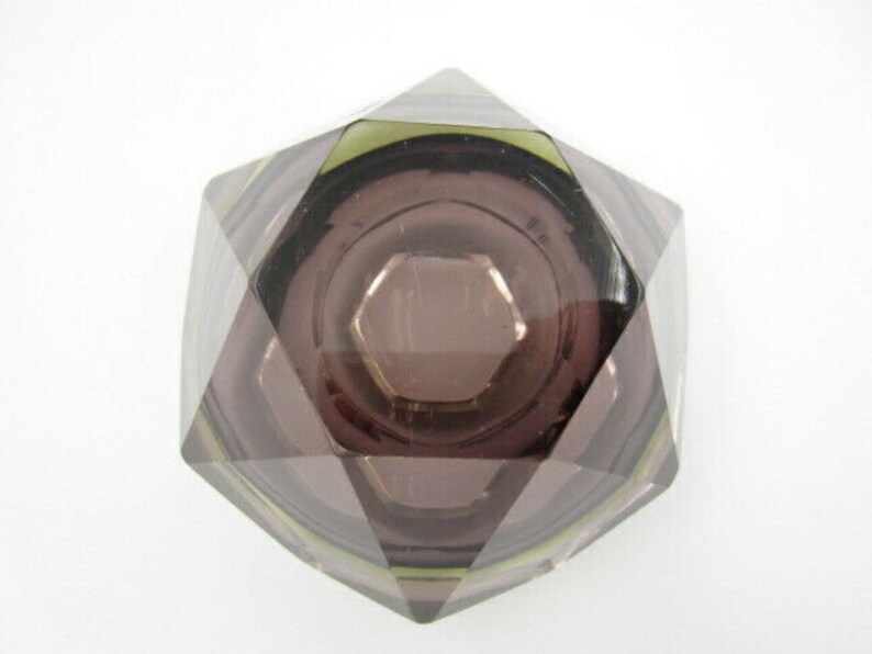 K&ouml;nnte beinhalten: Ein Aschenbecher aus violettem Glas mit geometrischem Design. Der Aschenbecher hat eine tiefe Vertiefung in der Mitte und ist aus klarem Glas mit einer violetten T&ouml;nung gefertigt.