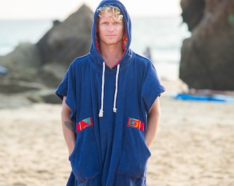 Könnte beinhalten: Ein blaues Kapuzenhandtuch mit bunten Verzierungen und Taschen. Das Handtuch besteht aus weichem, saugfähigem Material und ist perfekt zum Abtrocknen nach dem Schwimmen oder Surfen.