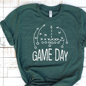 Puede incluir: Una camiseta verde con un dise&ntilde;o de jugada de f&uacute;tbol blanco y el texto "GAME DAY".