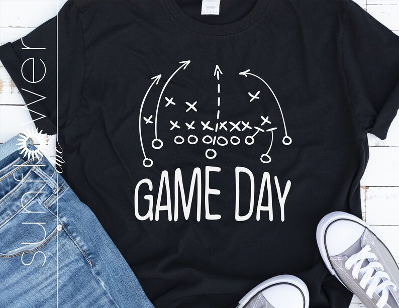 Puede incluir: Camiseta negra con un dise&ntilde;o de jugada de f&uacute;tbol americano blanco y el texto "GAME DAY" impreso en ella.