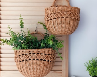 Cesto in vimini sospeso con manico per riporre oggetti e decorare.