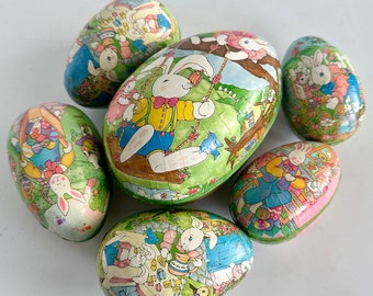 May include: Six colorful Easter eggs decorated with bunnies, flowers, and other spring-themed designs. The eggs are made of paper and have a glossy finish.