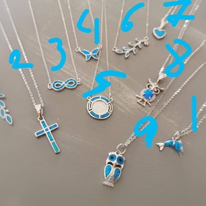 May include: Ten silver necklaces with blue opal pendants. The pendants include a cross, an owl, a butterfly, an infinity symbol, a dolphin, a leaf, and a circle with a design inside.