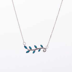 May include: A silver necklace with a delicate branch design featuring blue opal leaves. The branch has a curled end and is set on a silver chain.