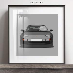 Op de afbeelding: Een zwarte en grijze Porsche 928 auto-illustratieprint. De auto is naar voren gericht met de koplampen en de grille zichtbaar. De print is op een grijze achtergrond.