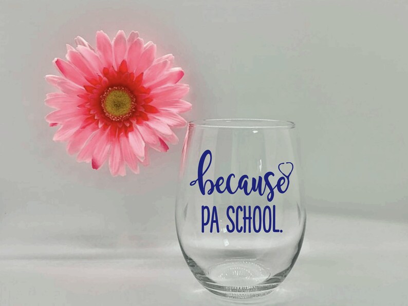 May include: A clear glass wine glass with a blue vinyl decal that says "because PA SCHOOL."  The decal also includes a small blue heart with a stethoscope inside.