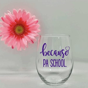 May include: A clear glass wine glass with a purple vinyl decal that reads "because PA SCHOOL."  The decal also includes a small purple heart with a stethoscope inside.
