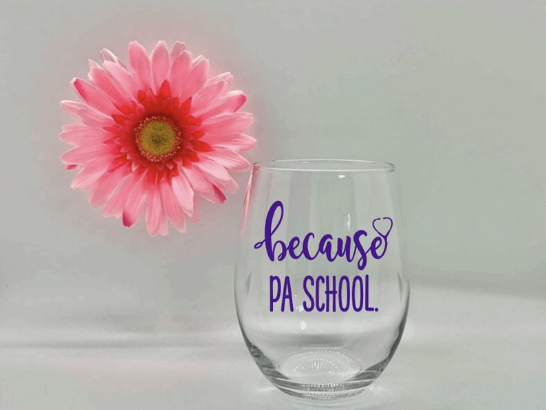 May include: A clear glass wine glass with a purple vinyl decal that reads "because PA SCHOOL."  The decal also includes a small purple heart with a stethoscope inside.
