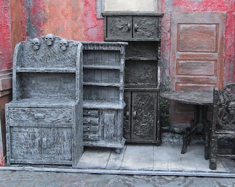 May include: A set of three black wooden cabinets with skull details. The cabinets have shelves and drawers. The cabinets are in a room with red walls and a wooden floor.