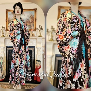 May include: A brown silk shawl with a floral print in shades of pink, blue, and yellow. The shawl has fringe trim and a turquoise beaded necklace.