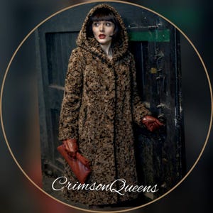 May include: A long, hooded brown coat with a textured pattern. The coat is buttoned up and worn with red gloves and a matching clutch. The text "Crimson Queens" is visible at the bottom.