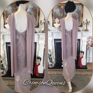 May include: A mauve formal gown with detailed beadwork and a matching shawl. The dress has a V-neck and a flowing, floor-length design. The shawl drapes over the shoulders. The text "CrimsonQueens" is visible at the bottom of the image.