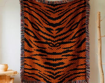 May include: A woven throw blanket with a tiger stripe pattern in orange and black. The blanket has a fringe border in a variety of colors.