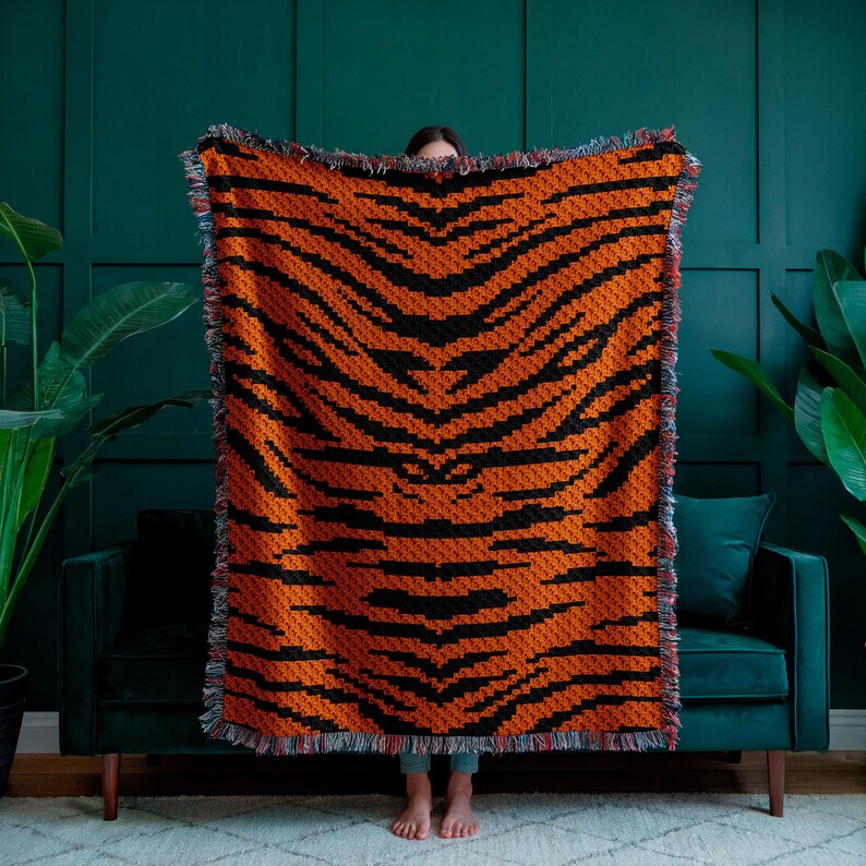 May include: A large orange and black tiger-striped woven throw blanket with fringed edges.
