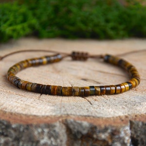 May include: A brown leather cord bracelet with brown and gold tiger's eye beads.