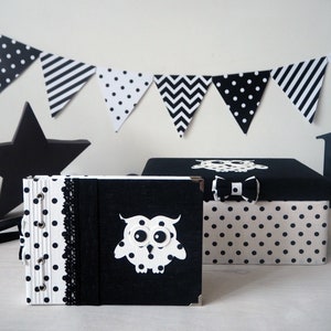 Puede incluir: Caja de almacenamiento de lunares blancos y negros con un diseño de búho negro y un lazo negro. La caja está al lado de un álbum de fotos de lunares blancos y negros con un diseño de búho negro.