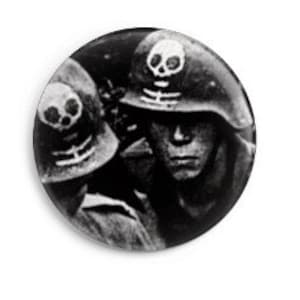Può includere: Foto in bianco e nero di due soldati che indossano elmetti con teschi e ossa incrociate dipinte.