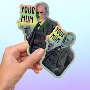 Könnte beinhalten: Zwei holografische Aufkleber mit einem Schwarzweißbild von Sigmund Freud und dem Text "Your Mum" in Schwarz.