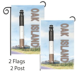 Op de afbeelding: Twee tuin vlaggen met een vuurtoren en de tekst "Oak Island" in bruine letters op een blauwe lucht achtergrond.