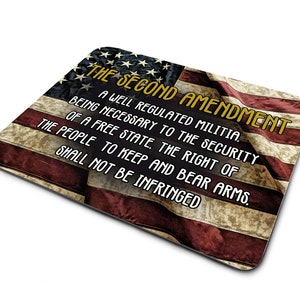 May include: A mouse pad with a faded American flag design and the text "THE SECOND AMENDMENT" in yellow. The text reads "A well regulated Militia, being necessary to the security of a free State, the right of the people to keep and bear Arms, shall not be infringed."