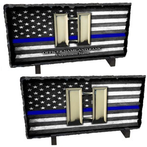 May include: A black and white American flag with a blue stripe across the middle. The flag is on a slate plaque with a silver double bar insignia and the text "OFFICER NAME AND RANK Department Name".