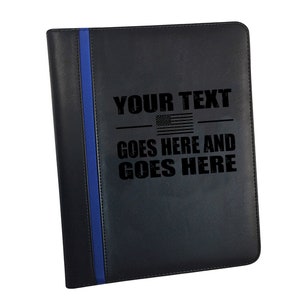 May include: Black leather binder with a blue stripe down the side. The binder has an American flag and the text "YOUR TEXT GOES HERE AND GOES HERE" engraved on the front.