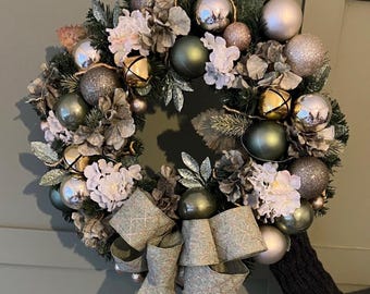 Sage Green y Champagne sostienen una gran corona navideña de lujo para puerta eterna