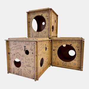 La casa para gatos Premium está hecha de cubos de cartón reciclable con un panel para rascar y un troquel de hierba gatera. El cubo mide 36 x 36 x 36 cm.