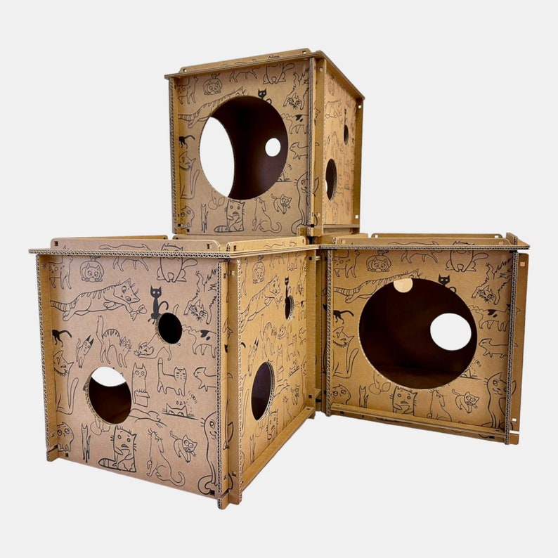 Pode incluir: Uma casa de brincar para gatos de cart&atilde;o com tr&ecirc;s se&ccedil;&otilde;es conectadas, cada uma com um buraco de tamanho diferente. O cart&atilde;o &eacute; impresso com um desenho de gato preto e branco.