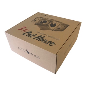 Pode incluir: Uma caixa de cart&atilde;o castanho com o texto "3x Cat House" e "Modular Cardboard" impresso na parte superior. A caixa tem uma imagem de uma casa para gatos feita de cart&atilde;o na parte superior. O logotipo Koto Moda est&aacute; impresso na parte inferior da caixa.