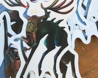 May include: A die-cut sticker featuring a dark green, four-legged creature with large, branching antlers, glowing yellow eyes, and a small yellow crown icon above its head. The creature has a hunched posture, sharp spines along its back, and thin limbs.