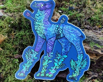 May include: A die-cut sticker featuring a stylized quadruped creature with fur in shades of blue and purple. The creature is pierced by two arrows and has clusters of light blue mushrooms growing from its legs and back, with glowing eyes.