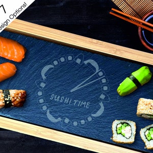 May include: A blue slate serving tray with a wooden frame, featuring a sushi-themed design with the text "Sushi Time". The tray is filled with various sushi rolls, including avocado, cucumber, and salmon.