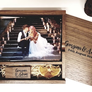 May include: A wooden box containing a photograph of a couple on a staircase with candles. The box is engraved with "Georgina & Adam 24th August 2019".