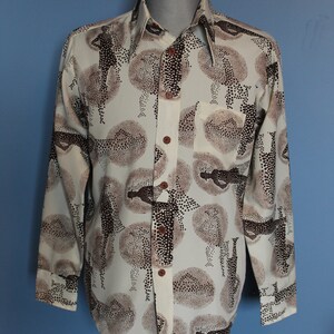 May include: A long-sleeved shirt with a white background and a brown abstract pattern. The shirt has a button-down collar and a button-up front.