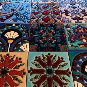 May include: A collection of colorful, hand-painted ceramic tiles with intricate geometric and floral designs. The tiles are arranged in a grid pattern, creating a visually appealing mosaic.