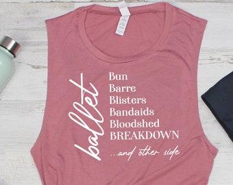 May include: A dusty rose muscle tank top with the word "ballet" in white script and a list of ballet-related terms. The image also includes a water bottle, dumbbells, and black leggings.