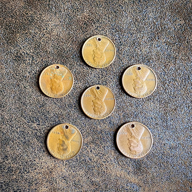May include: Six antique gold-colored metal tokens with a hole at the top. Each token has a raised image of a person's face and the text "5&cent;&cent;1" and "ALBERTI" on the front.