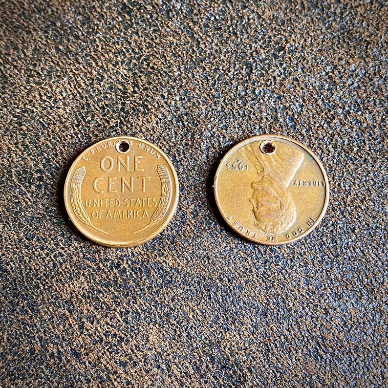 May include: Two copper US one cent coins. The obverse side features the words "One Cent" and "United States of America". The reverse side features a profile of Abraham Lincoln and the words "In God We Trust" and "Liberty".
