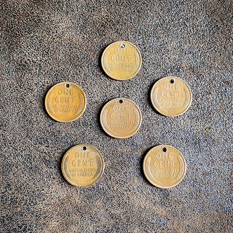 May include: Six antique copper-colored US one-cent coins with the words "One Cent" and "United States of America" on each coin.