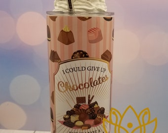 Könnte beinhalten: Ein rosa-weißer Becher mit Schokoladen-Motiv. Der Becher hat einen Strohhalm und einen weißen Deckel mit Schokoladen-Dekorationen. Der Becher zeigt eine Grafik mit einer Auswahl an Schokoladen mit dem Text "Ich könnte Schokolade aufgeben, aber ich bin keine Aufgeberin."